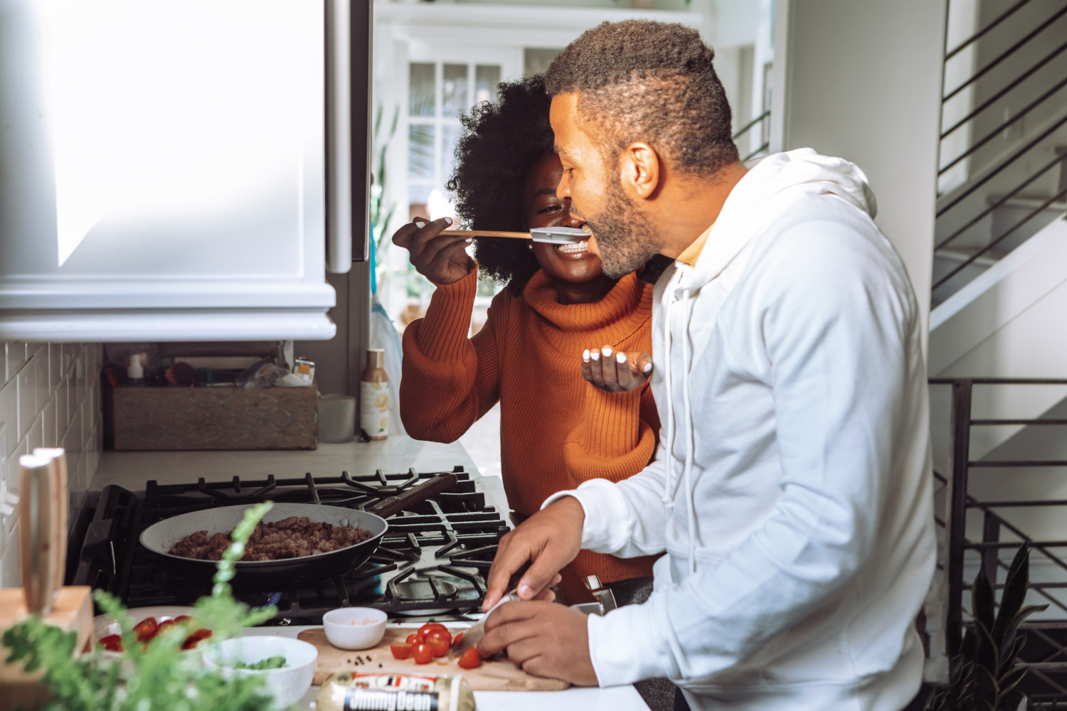 Couple tasting food while cooking